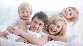 Blije familie in een licht huis die geniet van het wooncomfort en de kwaliteit van All Window kunststof kozijnen, deuren en gevelbekleding.