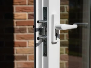 Wit uPVC raamkozijn met meerpuntssluiting op een Nederlandse bakstenen gevel, bestand tegen inbraakpogingen.